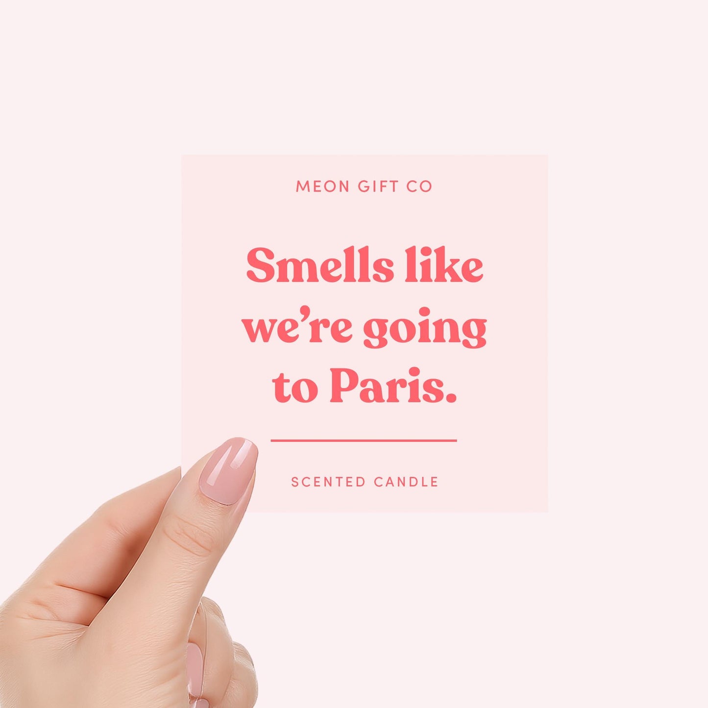 Scented candle label reading "Smells like we're going to Paris" held by a hand
