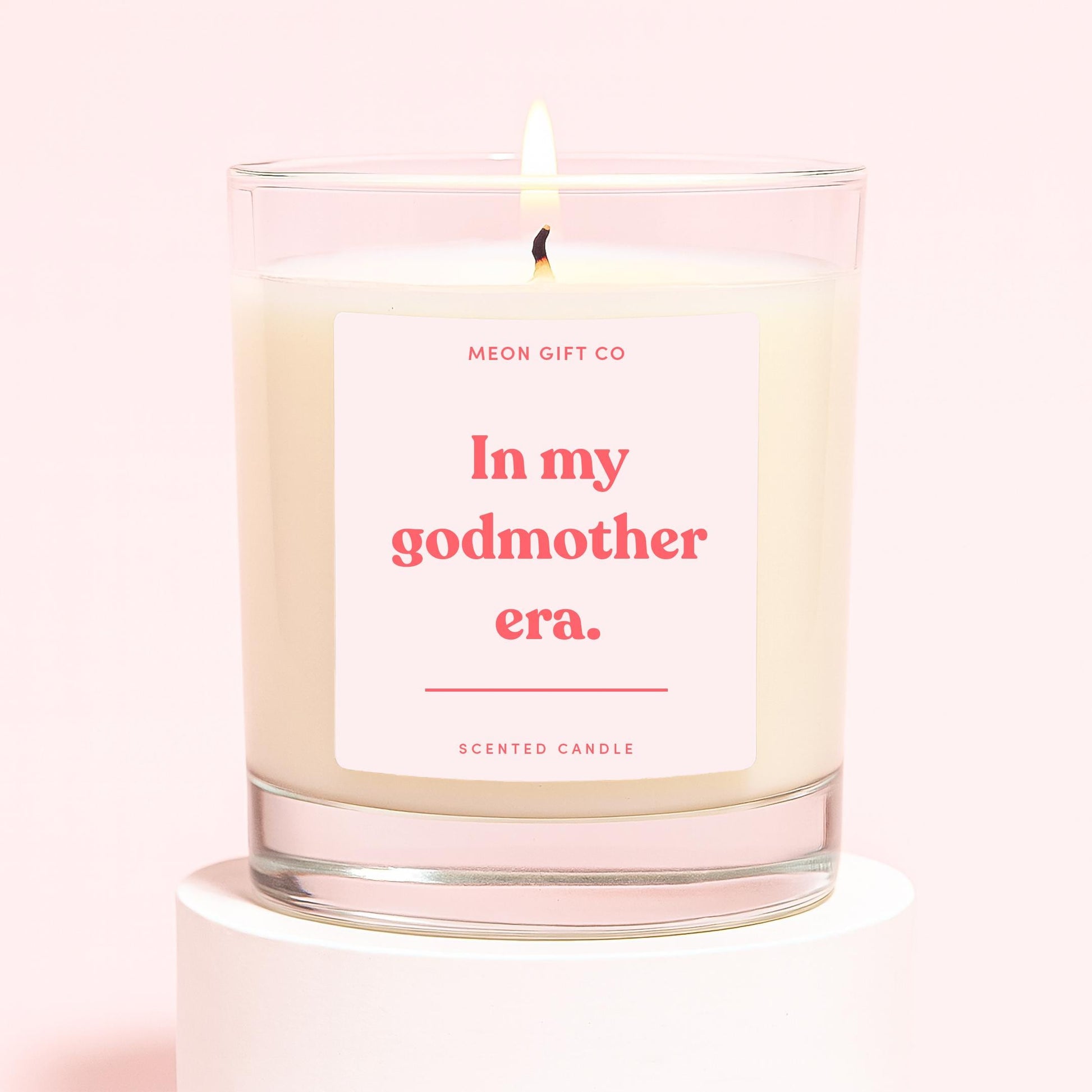 Scented candle in clear glass with cream wax and 'In my godmother era' label