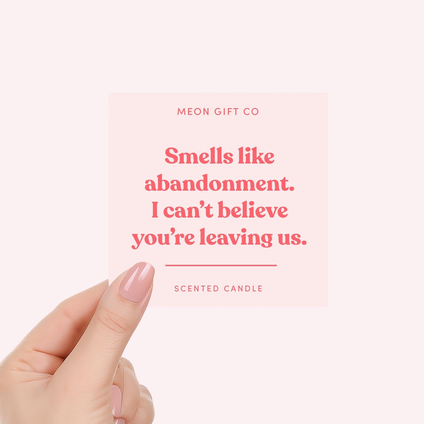 Abandonment scented candle label close-up with pink lettering held by hand