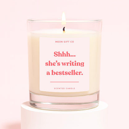 Scented candle in clear glass jar with cream wax and red message label