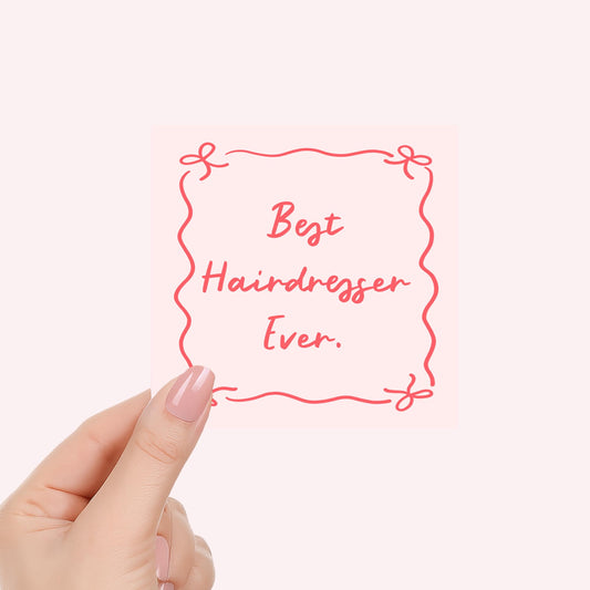 Hand holding candle label with red 'Best Hairdresser Ever' text over cream wax